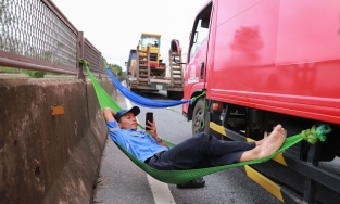 Tài xế mắc võng nằm chờ quốc lộ 1 thông xe