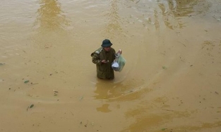 Thầy hiệu trưởng lội nước mang cơm cho sinh viên bị cô lập trong trường