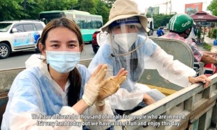 Thùy Tiên mặc áo bảo hộ để giới thiệu về Viêt Nam trong clip giới thiệu tại Miss Grand Internation