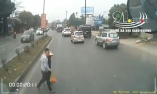 Hình ảnh nam tài xế ô tô chủ động dừng xe, đưa cụ bà sang đường