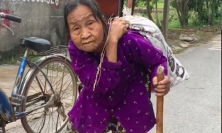 Cụ bà 85 tuổi lưng còng rạp vác bao tải trên lưng đi ủng hộ miền Trung
