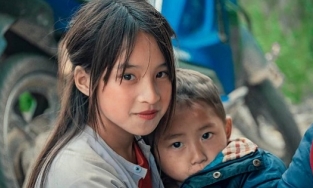 Bé gái Hà Giang bế em bên đường bão mạng với vẻ đẹp thuần khiết, xinh xắn