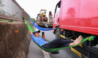 Tài xế mắc võng nằm chờ quốc lộ 1 thông xe