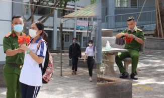 Hình ảnh 'ấm lòng' trong kỳ thi THPT Quốc gia: Chiến sĩ công an chăm chú kết vòng hoa cho nữ sinh đầu tiên ra khỏi phòng thi