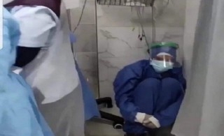 Nữ y tá ngồi một góc thẫn thờ nhìn bệnh nhân nhiễm Covid-19 qua đời