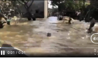 Xót xa cảnh bé trai bơi giữa dòng nước lũ ngập ngang cổ đi nhận đồ cứu trợ