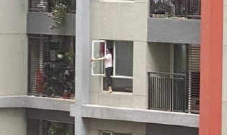 Nữ giúp việc liều mình trèo hẳn ra ngoài cửa sổ chung cư để lau kính