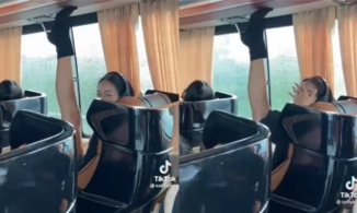 Một thí sinh Hoa hậu Hoàn Vũ ngồi dạng xoạc chân, chạm đế giày lên trần xe bus