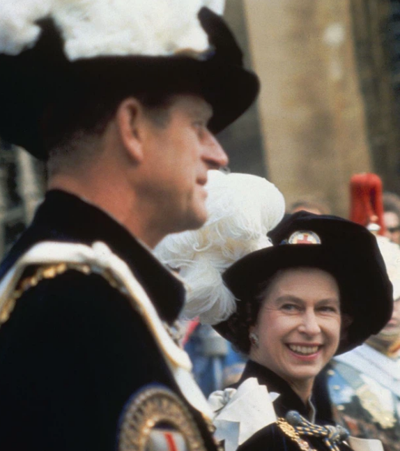 1957: Nữ hoàng Elizabeth mỉm cười với chồng mình, trong một buổi lễ tại Lâu đài Windsor vào năm 1957.