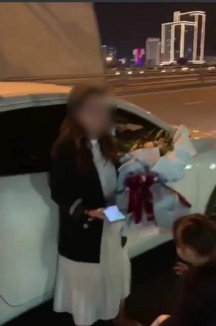 Người vợ được tặng hoa sau khi xuống xe trên cầu.
