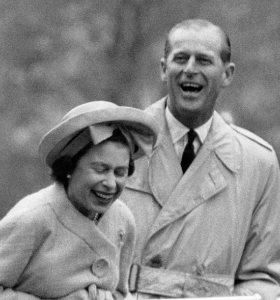 1963: Nữ hoàng Elizabeth và Hoàng thân Philip cười tươi khi xem màn nhào lộn trên dây do hai tân binh trẻ tuổi biểu diễn trong chuyến thăm của họ đến căn cứ quân sự ở xứ Wales vào mùa Xuân năm 1963.