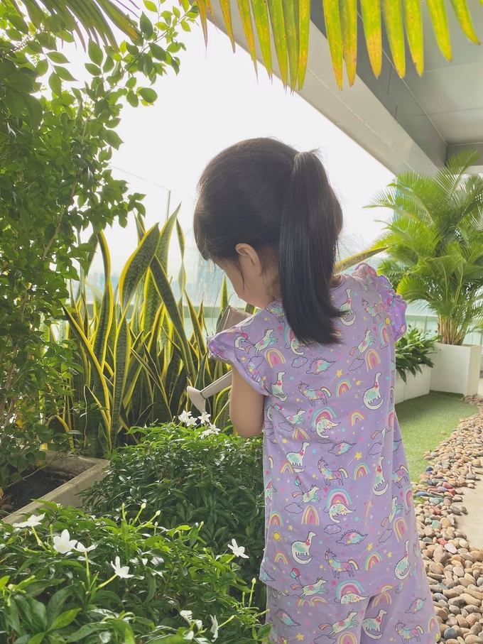 Cô bé ra dáng người lớn phụ mẹ tới cây, chăm sóc khu vườn nhà mình.