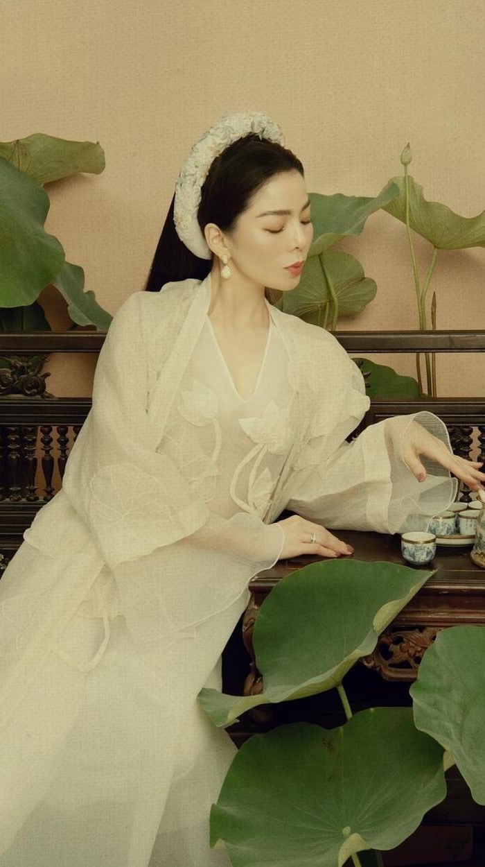 Hình ảnh Lệ Quyên hóa thân thành nàng thiếu nữ tửu trà bên sen duyên dáng với trang phục màu trắng tinh khôi.