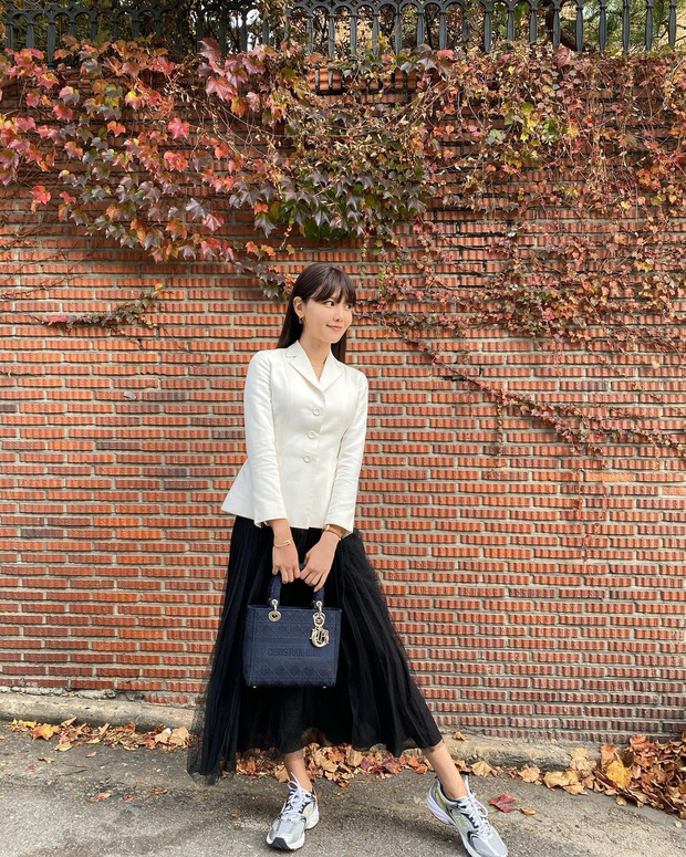 Sooyoung thì chọn cách chưng diện nguyên outfit đặc trưng của nhà mốt Dior với blazer trắng chiết eo cùng chân váy tulle màu đen kết hợp cùng chiếc túi xách cùng thương hiệu. Cô nàng cũng phá cách bằng việc chọn một đôi sneaker khoẻ khoắn, khiến set đồ trở nên ấn tượng hơn
