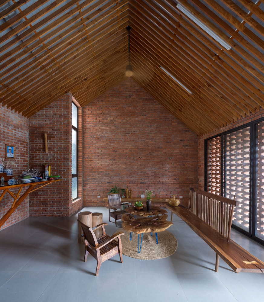 Phòng khách thiết kế tối giản với bộ bàn ghế gỗ kiểu cổ và thảm dệt tự nhiên.