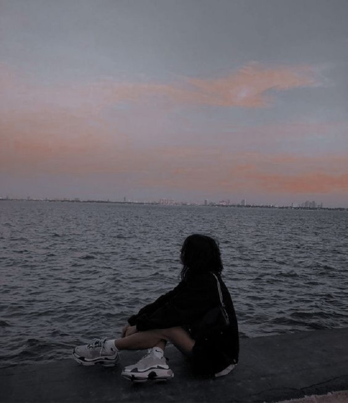 Cô gái ngồi vô định trước biển (Nguồn: Pinterest).