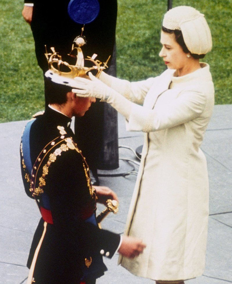 Nữ hoàng Anh diện bộ váy kèm áo khoác màu be sữa, cổ cao cứng cáp, trang trọng trong buổi sắc phong Charlie làm Hoàng tử xứ Wales. NTK đã tạo nên chiếc mũ turbo phủ ngọc trai, găng tay đồng điệu với trang phục cho nữ hoàng. 