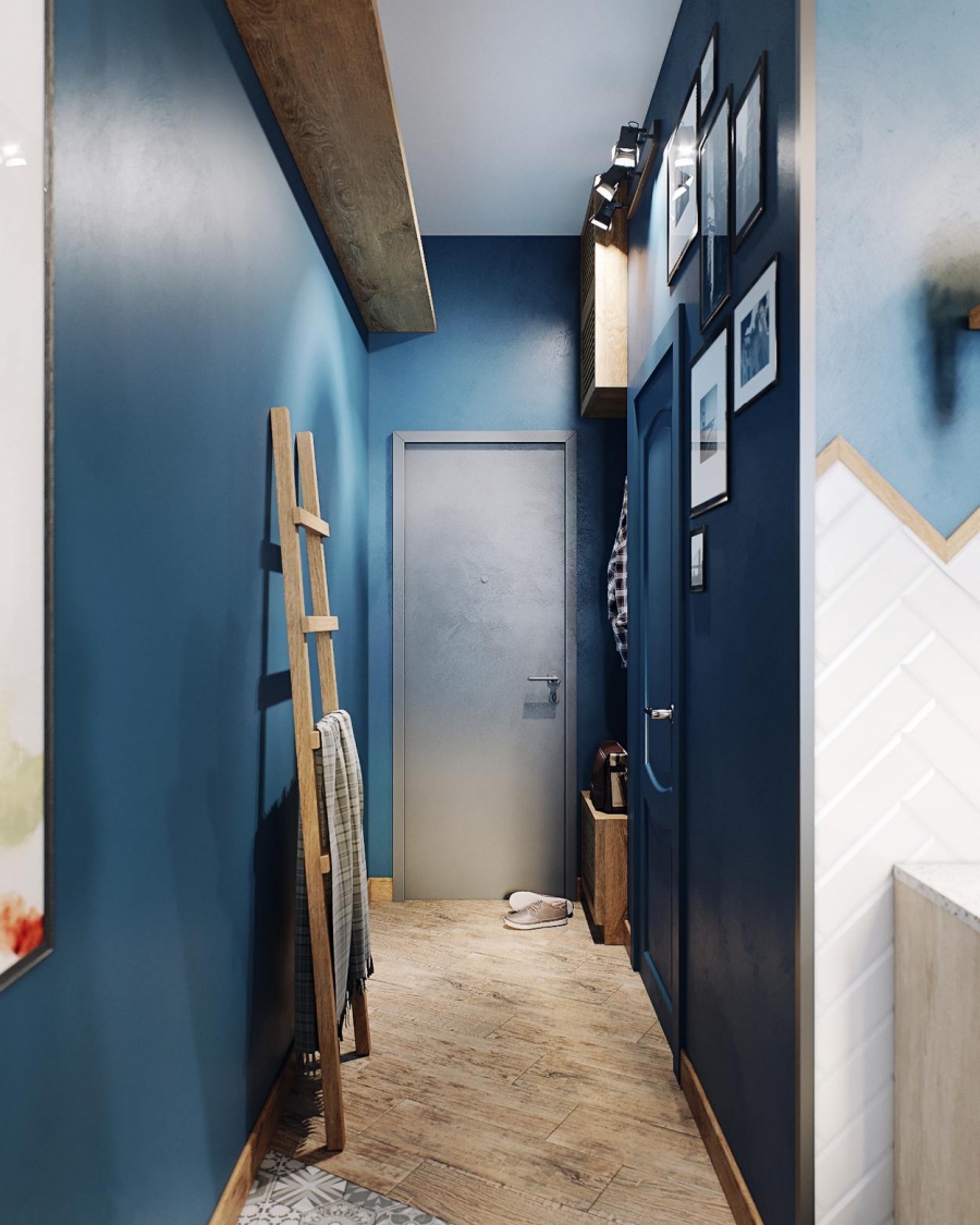 Lối vào căn hộ dài và hẹp nhưng vẫn tạo nên cảm giác thu hút nhờ sàn nhà lát gỗ tương phản với gam màu xanh lam đậm trên nền tường.