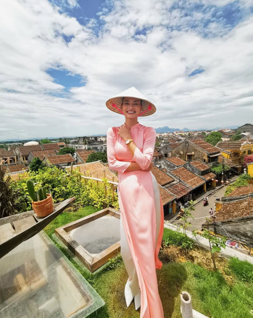 Pia Wurtzbach diện áo dài màu cam sữa, tươi cười giữa khung cảnh mái nhà cổ kính của phố cổ Hội An.