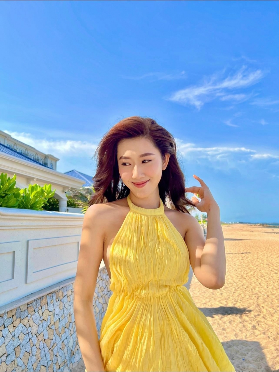 Thuỷ Ngân toả sáng trong chiếc váy cổ yếm chất liệu linen mát mẻ. Cô chọn màu vàng nắng để phù hợp với khung cảnh nên thơ của bãi biển mùa hè.