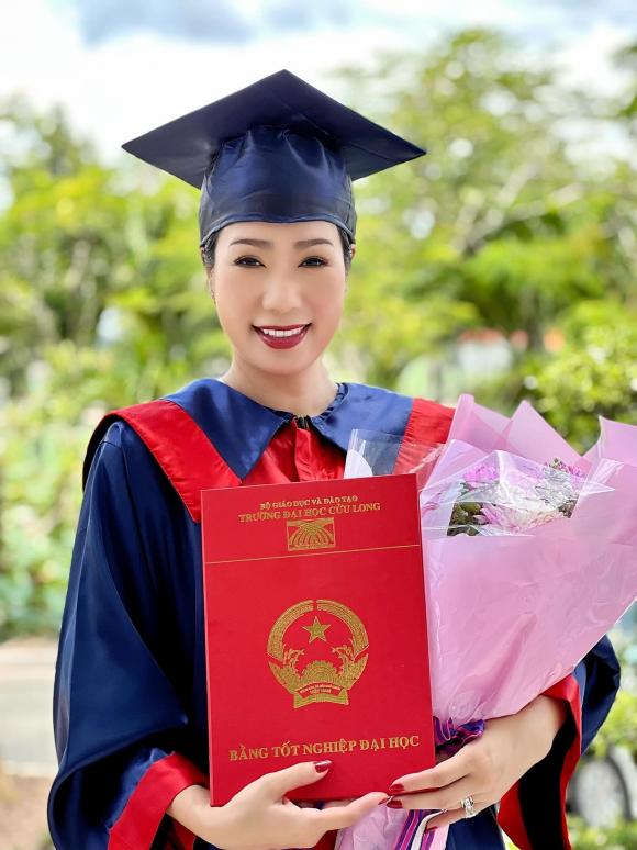 Nữ diễn viên vô cùng rạng rỡ và xinh đẹp trong bộ trang phục tốt nghiệp của trường, trên tay là tấm bằng và bó hoa tươi thắm.