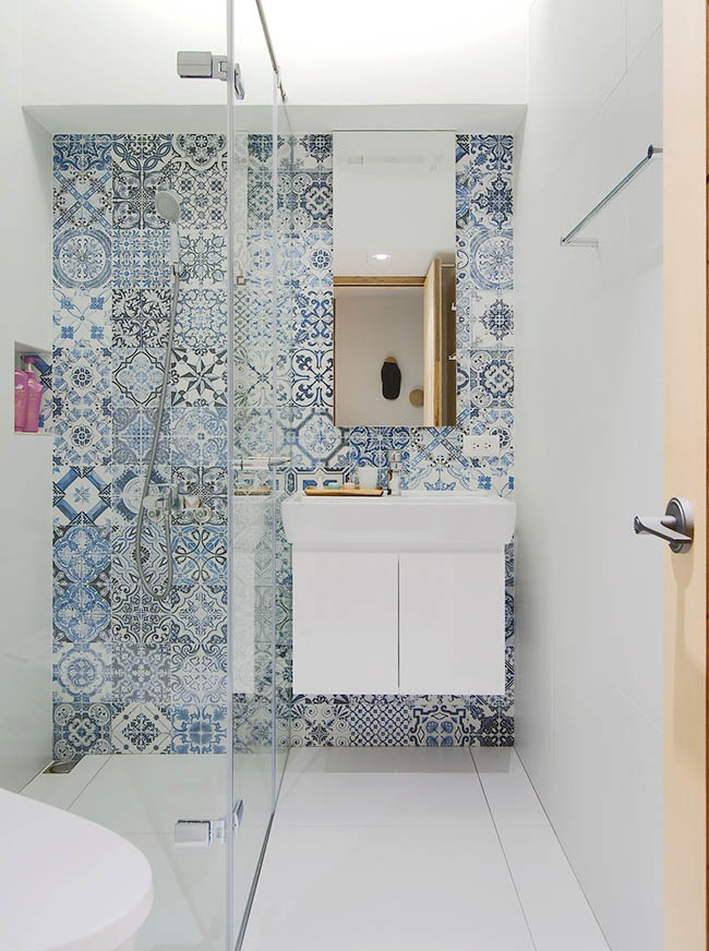Phòng tắm thứ 2 sử dụng gạch ốp hoa văn màu xanh trang nhã, mát mẻ. Chiếc tủ vanity gắn tường giúp giải phòng diện tích sàn, đồng thời tủ lưu trữ kết hợp bề mặt gương soi cũng giúp không gian đẹp mắt và tiện nghi hơn.