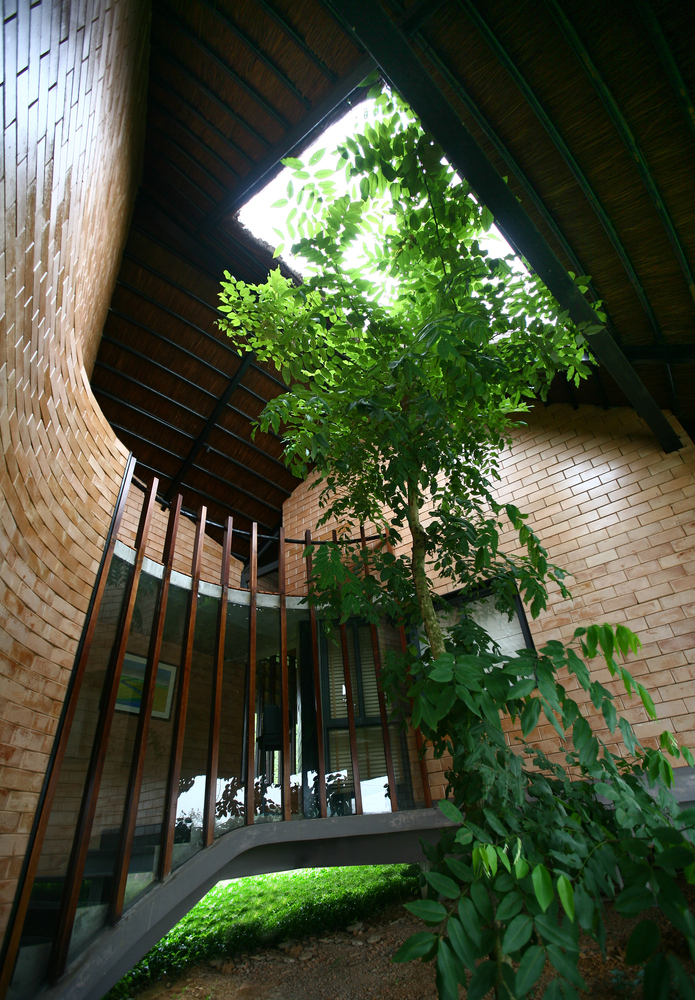 Cầu thang dẫn lối lên tầng trên thiết kế uốn lượn với đường cong uyển chuyển mang lại điểm nhấn kiến trúc độc đáo cho ngôi nhà.