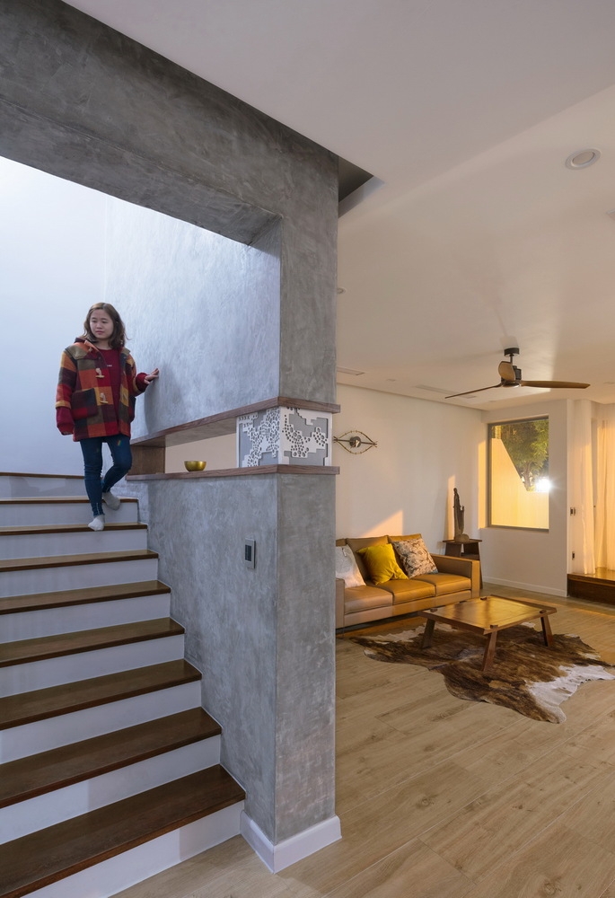 Bức tường ngăn cách không gian phòng khách và cầu thang dẫn lối lên tầng trên được 'thu hẹp' lại để tạo cảm giác thông thoáng.