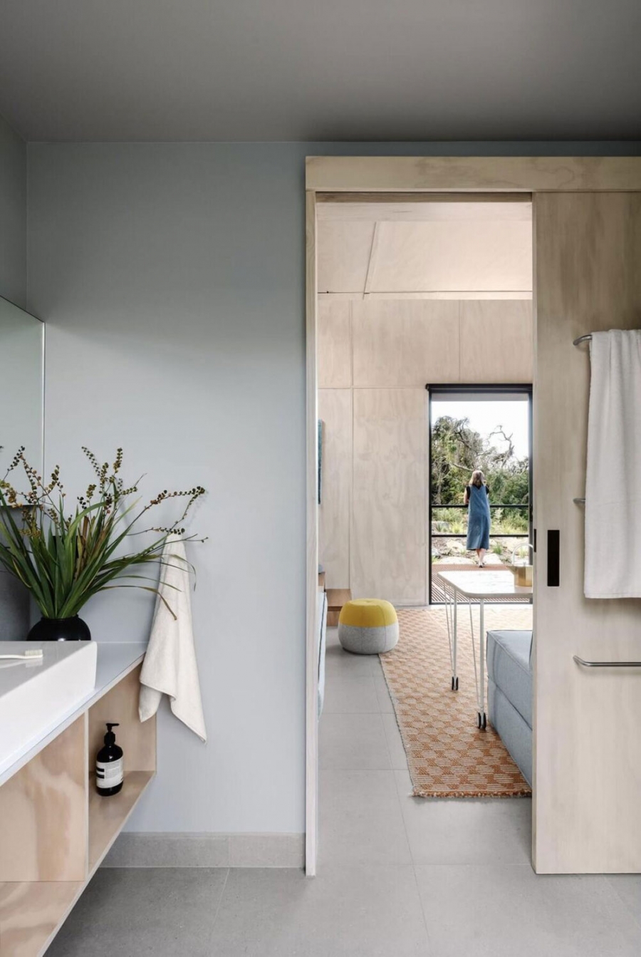 Phòng tắm được bố trí phía sau phòng khách, nội thất bằng gỗ nhẹ nhàng, tươi sáng, tủ vanity gắn tường giúp giải phóng diện tích sàn và dễ dàng vệ sinh.