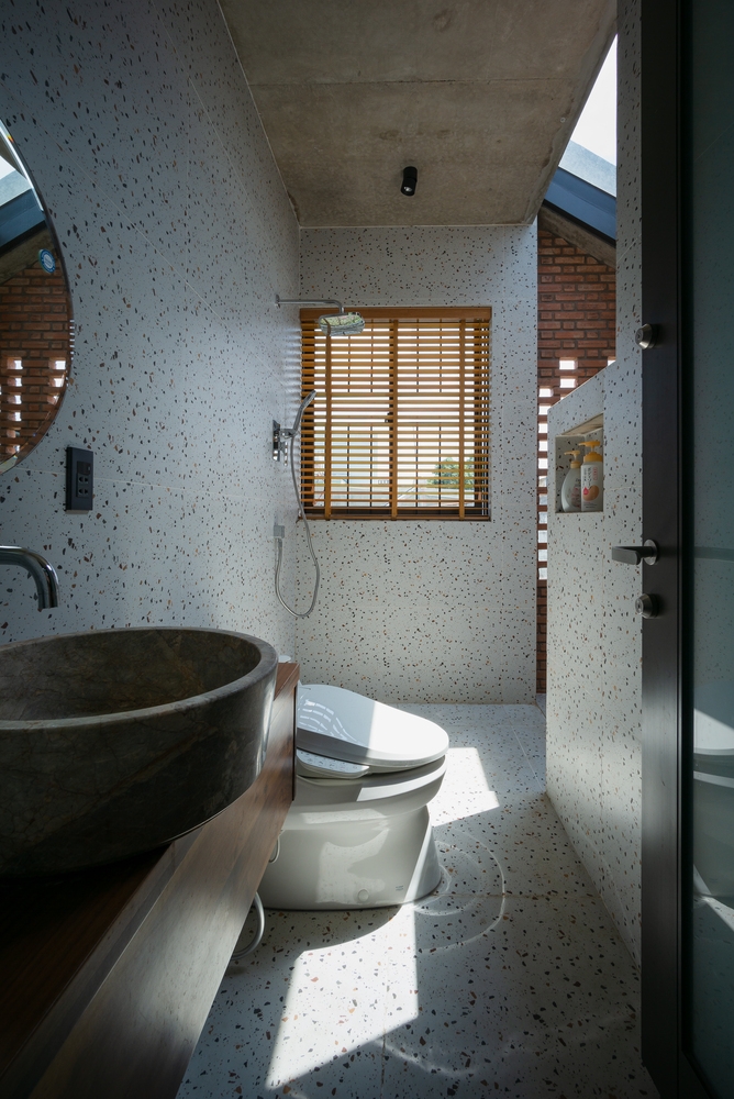 Phòng tắm trên tầng 2 tuy nhỏ nhưng xinh xắn với gạch ốp lát họa tiết terrazzo nhẹ nhàng. bồn rửa tay bằng đá trên mặt bàn gỗ cũng thể hiện được phong cách mộc mạc xuyên suốt tổng thể.