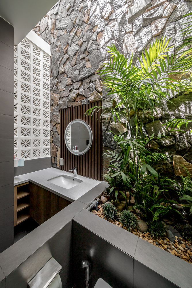 Không gian phòng tắm cũng được trang trí bởi gạch bông gió, lam gỗ, tường ốp đá và cây xanh sống động.