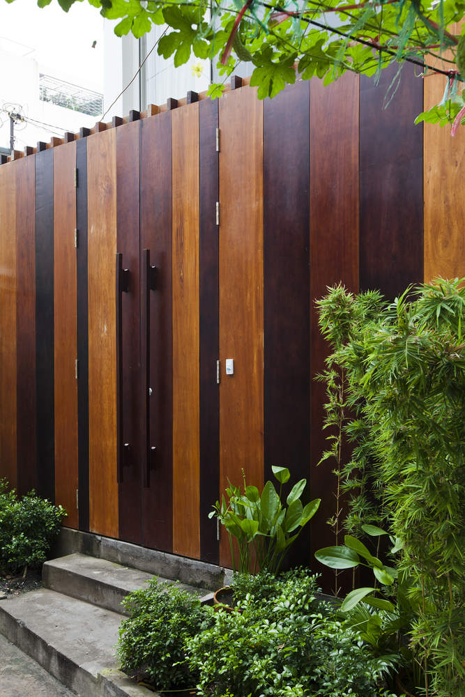 Mặt tiền ngôi nhà gây ấn tượng với cửa gỗ được tạo nên từ những thanh gỗ nhiều sắc thái đậm nhạt vừa kiên cố vừa ấm áp.