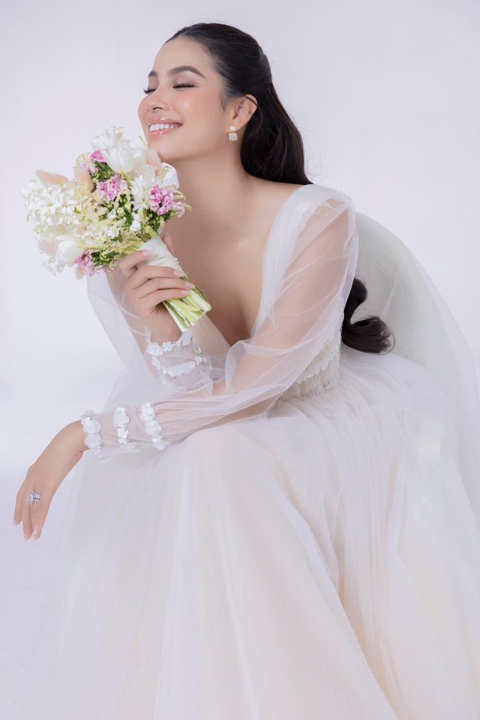 Một chiếc váy cưới nữ tính trong BST váy cưới của Phạm Hương. Thiết kế trông đơn giản mà tinh tế với phần vải xuyên thấu bên ngoài, tạo vẻ đẹp quyến rũ mà không kém phần thanh lịch.