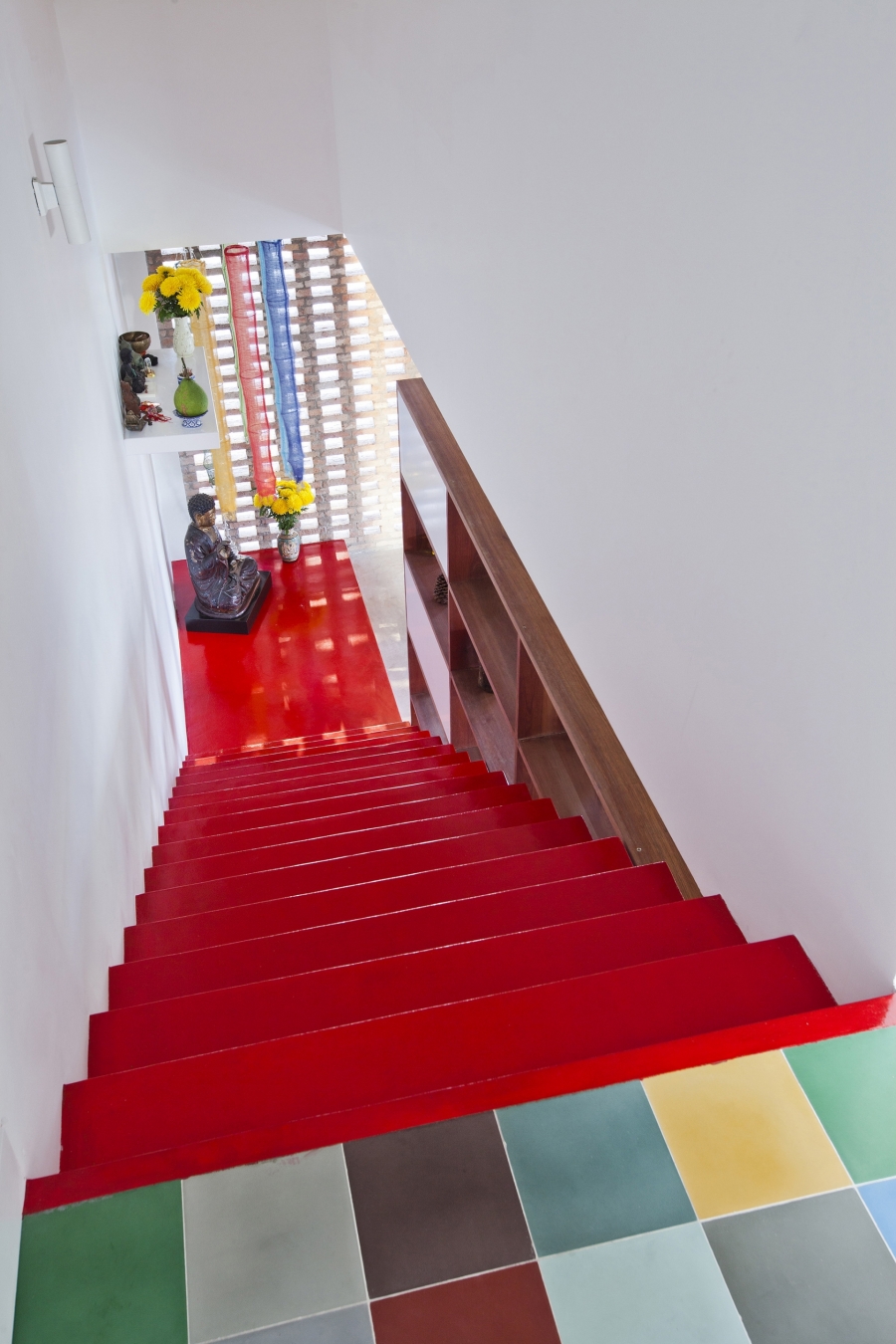 Chiếc cầu thang màu đỏ rực rỡ nối liền các tầng nhà với nhau tạo thành một điểm nhấn vô cùng bắt mắt.