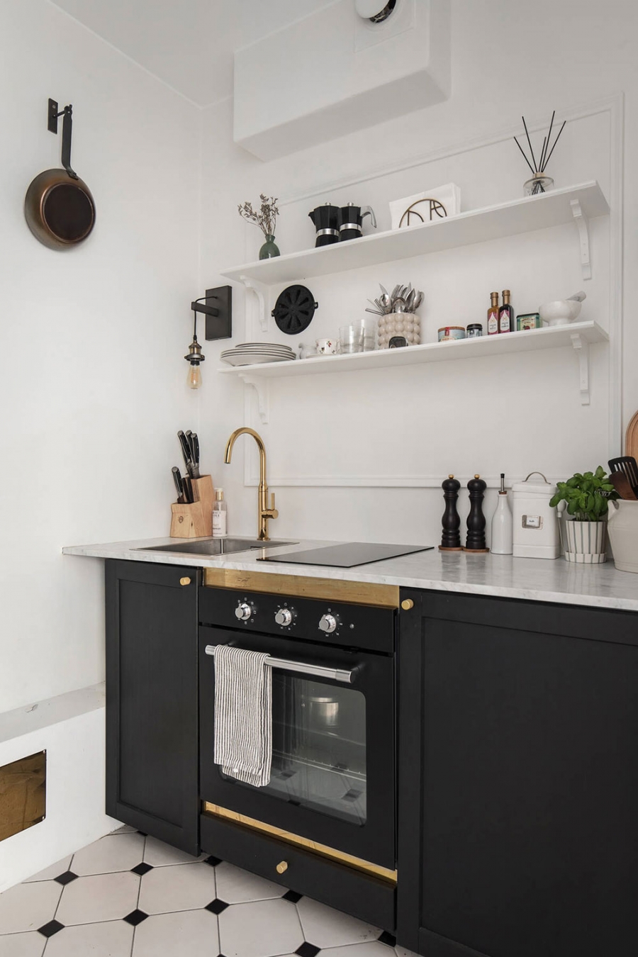 Riêng phòng bếp được lát sàn gạch màu trắng - đen để tạo sự khác biệt, đồng thời giúp vệ sinh dễ dàng hơn. Bếp thiết kế kiểu chữ I nhỏ gọn nhưng đầy đủ tiện nghi cho chủ nhân.
