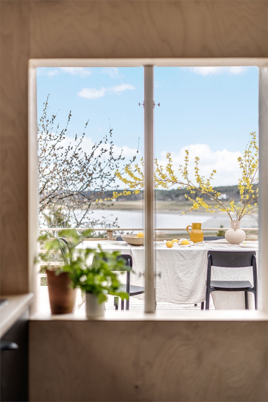 Bệ cửa sổ phòng bếp được trang trí bởi những chậu cây thảo mộc nhỏ. Từ cửa sổ này, bạn có thể phóng tầm mắt ngắm nhìn khu vực ăn uống ngoài trời giữa thiên nhiên tươi đẹp.
