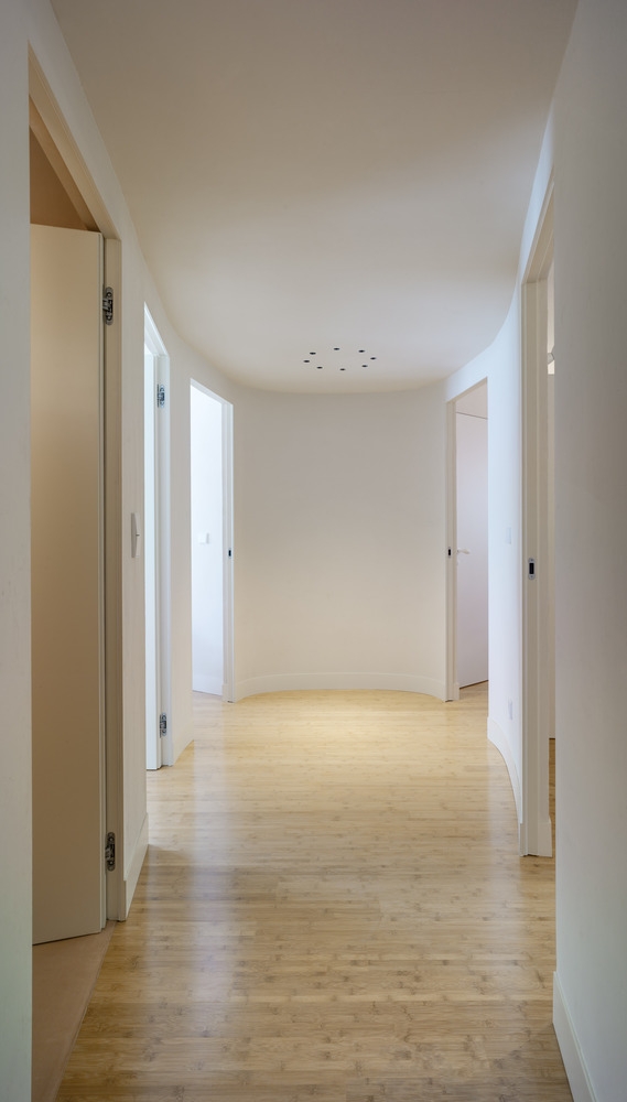 Ngay từ lối đi, bạn đã có thể cảm nhận những đường cong của nội thất xuất hiện ở các bức tường và cửa của các căn phòng chức năng khác nhau. Lối đi hoàn toàn giữ sạch sẽ cho cảm giác 'trơn tru' xuyên suốt.