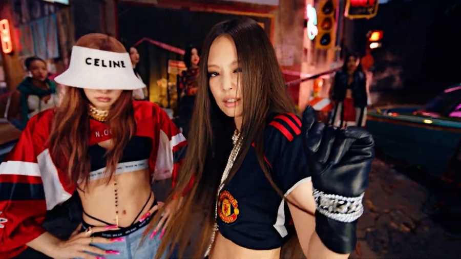 Jennie đã biến hóa chiếc áo đồng phục Manchester United thành item croptop khoe eo quyến rũ. Cô mặc outfit đậm chất hip hop trong phần rap với Lisa.