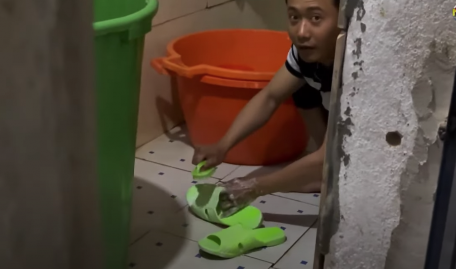 Khuôn mặt thất thần của Quang Linh Vlogs khi bị bắt quả tang đang cọ dép 'người thương'.