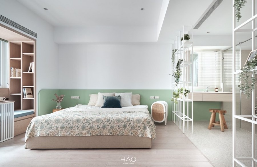Phòng ngủ đầu tiên được thiết kế theo phong cách nhẹ nhàng, gắn kết với thiên nhiên nhờ gam màu xanh lá cây, bộ drap giường và kệ mở cũng ngập tràn chậu cảnh.
