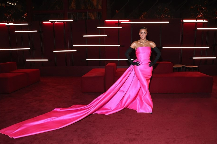 Tại buổi dạ tiệc, Kim Kardashian diện một chiếc váy màu hồng nóng bỏng bắt mắt, ôm sát eo và nổi bật với đuôi váy dài.