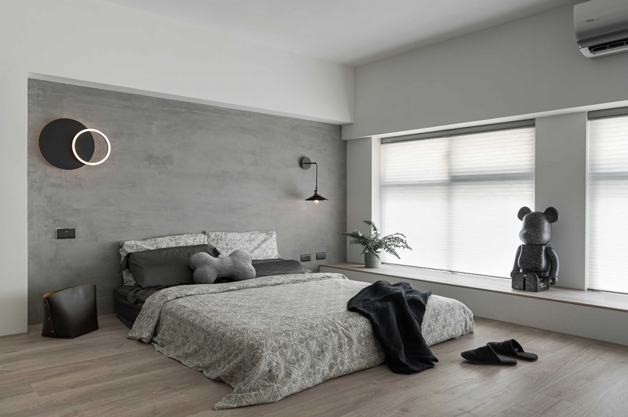 Phòng ngủ vẫn giữ bảng màu chủ đạo của căn hộ và xám, trắng và đen, với chiếc giường thấp sàn tạo cảm giác trần nhà cao hơn thực tế. 