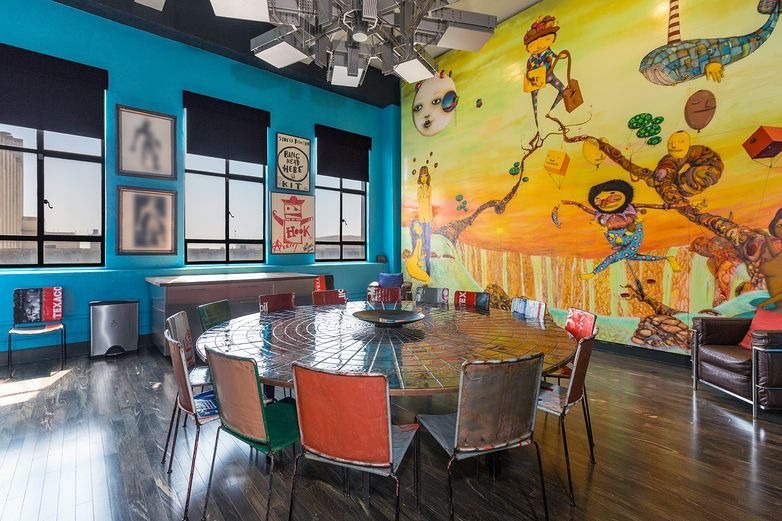 Không gian ăn uống nổi bật với bức tường màu xanh và nhiều hình vẽ độc đáo