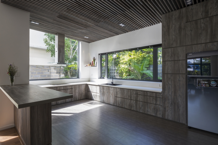 Phòng bếp gọn gàng với tone màu trầm ấm, sạch sẽ, xung quanh là cửa sổ tường kính đón nhận nguồn ánh sáng tự nhiên dồi dào vào ban ngày.