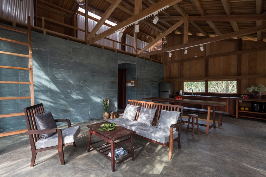 Không gian phòng khách thiết kế mở với bộ bàn ghế gỗ đơn giản đậm chất làng quê Việt Nam.