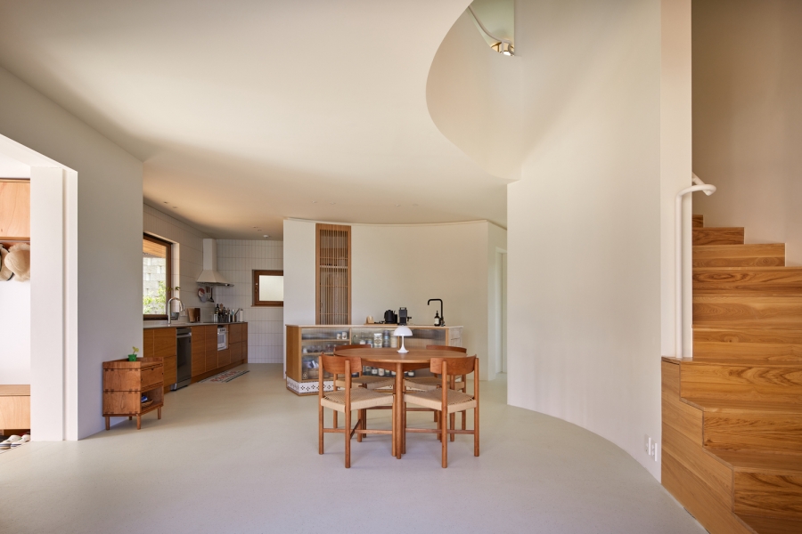 Phòng bếp và phòng ăn được thiết kế liền kề tạo nên sự tiện lợi giữa không gian nấu nướng - ăn uống. Bếp thiết kế kiểu chữ với tủ gỗ tương phản với gạch ốp tường thẻ dọc màu trắng.