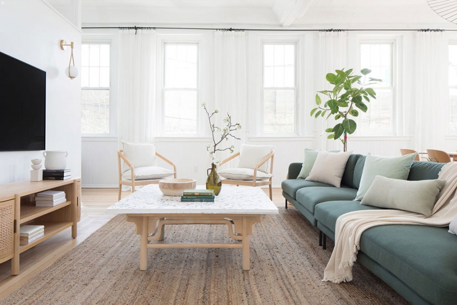 Căn hộ thiết kế theo phong cách Scandinavian thanh lịch, phòng khách với bộ ghế sofa màu xanh dịu nhẹ, cây cảnh và hoa trang trí tươi mát.