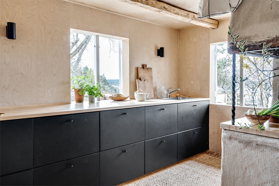 Phòng bếp thiết kế với gam màu đen bí ẩn của hệ thống tủ bếp cho cái nhìn mạnh mẽ cũng như tương phản với nội thất gam màu trung tính nhẹ nhàng xung quanh.