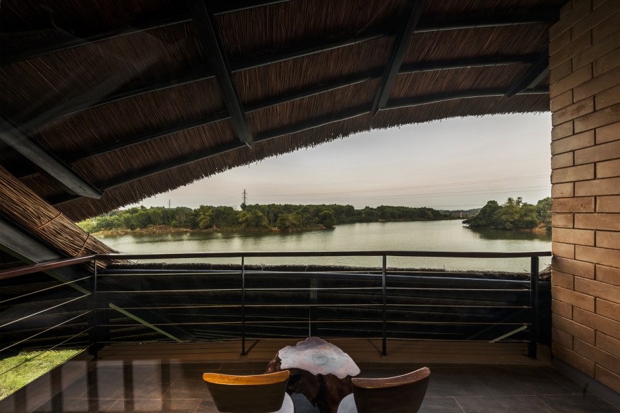 Một góc nhỏ cực 'chill' với bộ bàn ghế uống trà bằng gỗ, nhìn ra khung cảnh hồ nước trong vắt yên tĩnh, bên trên là mái rạ đậm chất làng quê Việt.