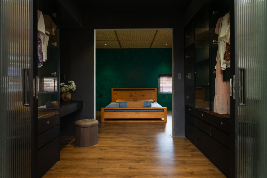 Không gian phòng ngủ với bức tường màu xanh ngọc lục bảo tương phản với tone gỗ và xám đen của nội thất. Phòng thay đồ, trang điểm với thiết kế sang chảnh cho gia chủ.